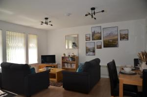 a living room with two chairs and a table at SCOTTISH HIGHLANDS Superb 2 bedroom apartment. in Invergarry