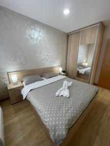a bedroom with a bed with a stuffed animal on it at City centar lux apartman in Zlatibor