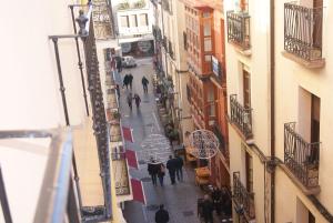 un grupo de personas caminando por una calle con sombrillas en Pensión Entreviñas, en Logroño