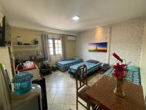 a living room with two beds and a table in a room at Residence Fonteles in Sobral