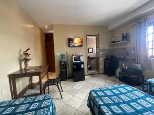 a room with two beds and a kitchen with a table at Residence Fonteles in Sobral