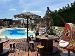 a patio with tables and chairs next to a pool at Le Relais de la Chouette in Berson +25 photos