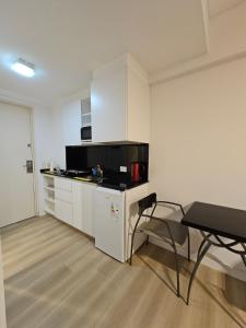 a kitchen with white cabinets and a table and a chair at Tempora 621 in Buenos Aires +4 photos