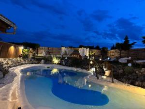 a swimming pool in a backyard at night at Le Relais de la Chouette in Berson