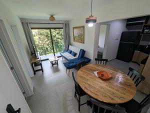 a dining room and living room with a wooden table at Guaramiranga - Apto próximo ao centro - Park Serra Bella in Guaramiranga