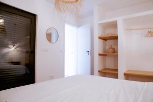 a white bedroom with a bed and a mirror at Mar-Ria 4 in Fuzeta +10 photos