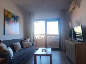 a living room with a couch and a tv and a table at Enebral 341 in Punta Umbría