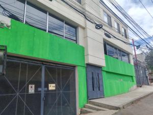 a green and white building with a garage at Departamento céntrico in Tijuana