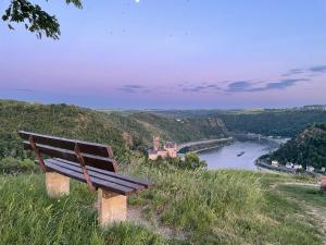 a bench sitting on top of a hill overlooking a river at Loreleyblick-Ferienwohnung am Rheinsteig - Natur und Aussicht in Patersberg +11 photos