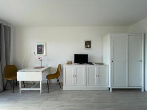 a white room with a desk and a white cabinet at Loreleyblick-Ferienwohnung am Rheinsteig - Natur und Aussicht in Patersberg