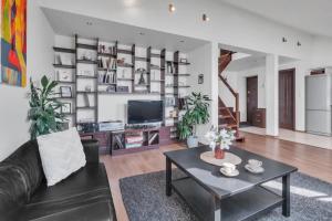 Una sala de estar con un sofá y una mesa de café. en Vilnius Old Town Amber Penthouse, en Vilna
