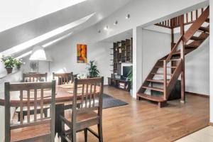 comedor y sala de estar con mesa y escaleras en Vilnius Old Town Amber Penthouse, en Vilna