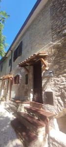 a stone building with a door and steps in front at Cottanello,"La casa del sole" in Cottanello