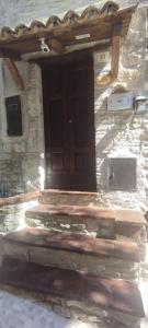 a stone building with a wooden door and stairs at Cottanello,"La casa del sole" in Cottanello