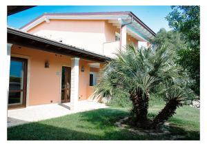 a palm tree in front of a house at La Mora Bianca in Assemini