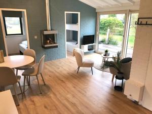 a living room with a table and chairs and a fireplace at Vakantiehuis Nynke in Grou