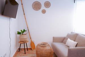 a living room with a couch and a tv at Mar-Ria 2 in Fuzeta