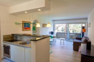 Una cocina con fregadero y una sala de estar. en Lugano Lakefront - Private Beach & Pool, en Melano