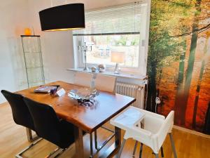 a dining room table with chairs and a window at Chalet an der Bode - Schicke 3 Zi Fewo mit Balkon in Braunlage