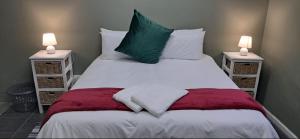 a bedroom with a large bed with two night stands at Strand Overnight - 24 Hour check-in - close to major private hospitals - sleeps 1- 4 guests - self catering - quiet neighborhood - week night low rate for single guest - weekends min 2 nights in Strand