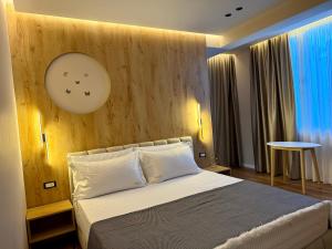 a bedroom with a bed with a clock on the wall at Villa24 Vlore in Vlorë