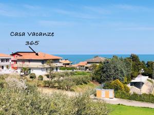 a view of a house with the ocean in the background at Casa vacanze 365 - verde in Tortoreto Lido