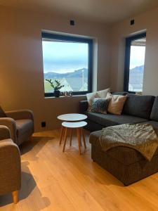 a living room with a couch and a table at Nybygd og sentral leilighet in Vestvågøya +9 photos