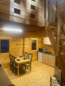 a kitchen and dining room with a table and chairs at Chatka na Górce in Okół