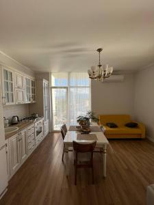 eine Küche mit einem Tisch und einer Couch in einem Zimmer in der Unterkunft alisas home 7 in Kobuleti