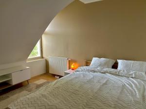 a bedroom with a white bed and a window at Pargi katusekorter in Kuressaare