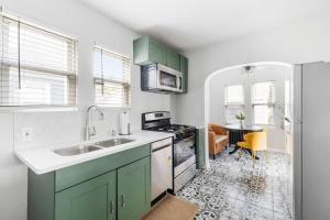 クイーンズにある3BR w/Office+Basement/Utilities+Parking/Near LIRRのキッチン(緑のキャビネット、シンク付)