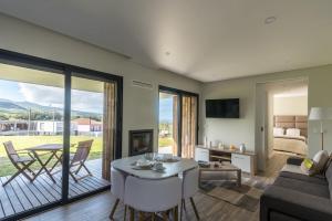 a living room with a couch and a table at Vila Vicente Jacuzzi, Sauna and Parking in São Vicente Ferreira