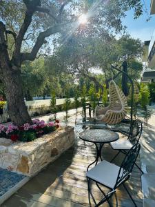 a patio with a table and chairs and a tree at Danielli Luxury Villas in Skala Rachoniou
