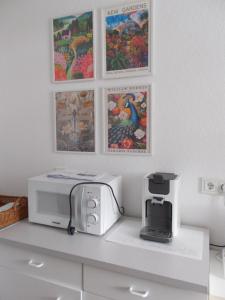 ウスラーにあるNatur und Ruhe - für Ruhe suchendenの電子レンジとトースターとポスターが置かれたキッチンカウンター