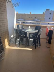 stół i krzesła na balkonie ze statkiem w obiekcie Marina d'Or, apartamentos Valparaíso w mieście Oropesa del Mar