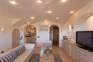 a living room with a couch and a tv at Luxury Seaview Villa - Villa Marinella in San Teodoro