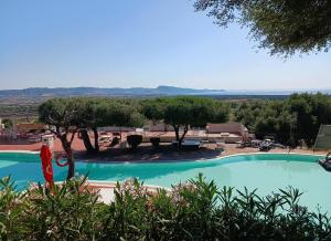 a large swimming pool with a picnic table and trees at BeB con piscina Villa del Borgo in Badesi