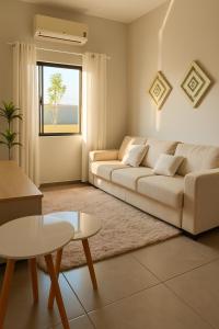 a living room with a white couch and a table at Casa de Campo proximo aos Pontos Turisticos in Foz do Iguaçu