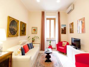a living room with a white couch and red chairs at New Apartment Sistina Trevi-Spagna in Rome
