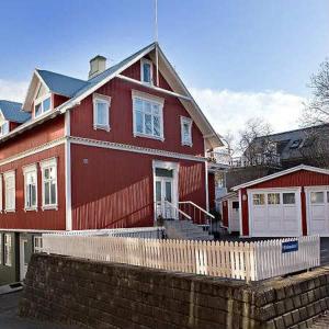 a red house with a fence in front of it at The Rock Village Nook in Reykjavík