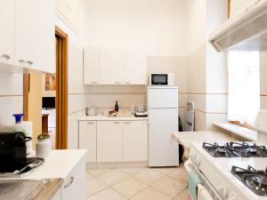 ローマにあるNew Apartment Sistina Trevi-Spagnaのキッチン(白いキャビネット、白い冷蔵庫付)