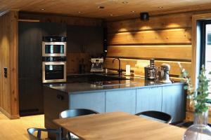 a kitchen with a counter and a table with chairs at Exclusive Fjord Lodge with Private Jacuzzi and Epic Views in Lii