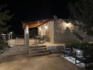 a patio with chairs and tables at night at Villa Maginja in Sutivan +37 photos