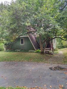 une maison verte avec un arbre en face dans l'établissement Country suite with bath and laundry, à Athens