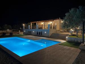 a swimming pool in front of a house at night at Villa Maginja in Sutivan