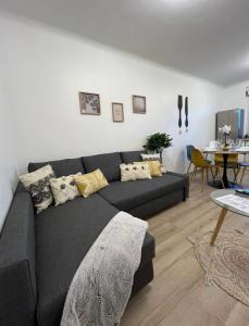 a black couch in a living room with a table at PARIS-MONTROUGE Magnifique Appartement 2 pièce de 36m2 - très cosy pour 1 à 5 personnes refait à neuf - ENTIRE APARTMENT LUXIRIOUS AND WARM - Montrouge Paris 14ème - Proche Aéroport Orly & Parc Expositions Porte de Versailles FREE WIFI GRATUIT in Montrouge