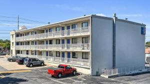 un edificio con un camión rojo estacionado en un estacionamiento en Motel 6-Maple Shade Township, NJ - Philadelphia - Mt Laurel, en Maple Shade