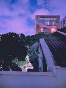 a statue on the side of a building with a house in the background at Big Place in Rio de Janeiro