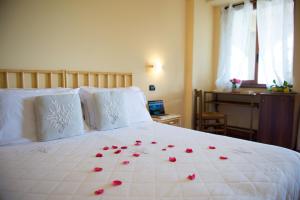 a bed with a white comforter and pillows at 'A Nuciara Park Hotel & Wellness Center in Furci Siculo