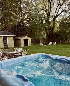 a swimming pool in a yard with a table and chairs at Chic Dunes Cottage with HOT TUB near Warren Dunes 
